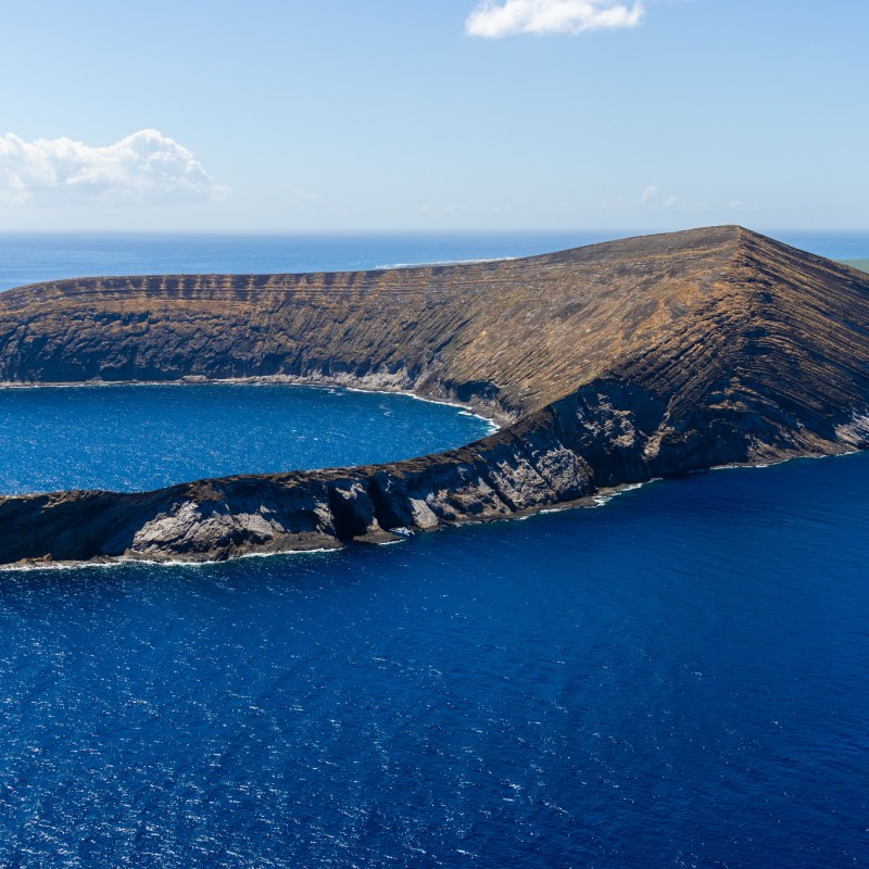 a body of water with a mountain in the ocean